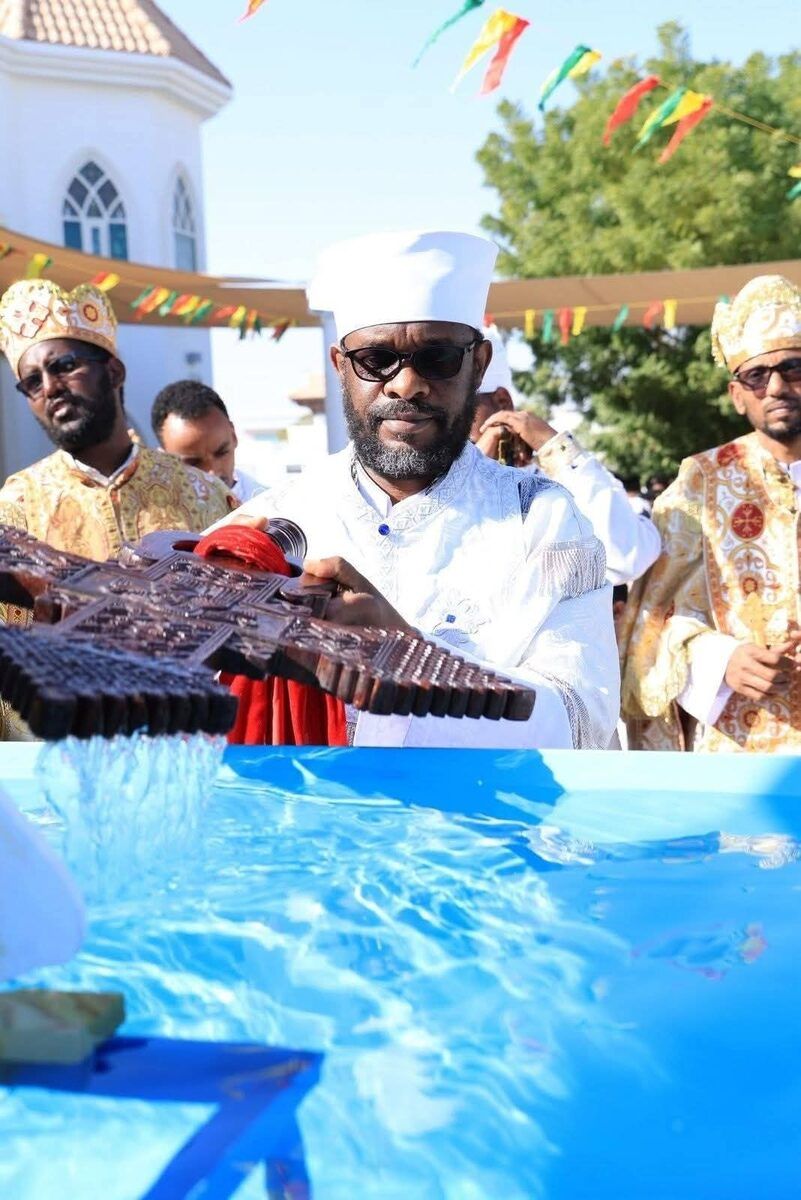 Priest blessing water with an Ethiopian Orthodox cross during Timkat