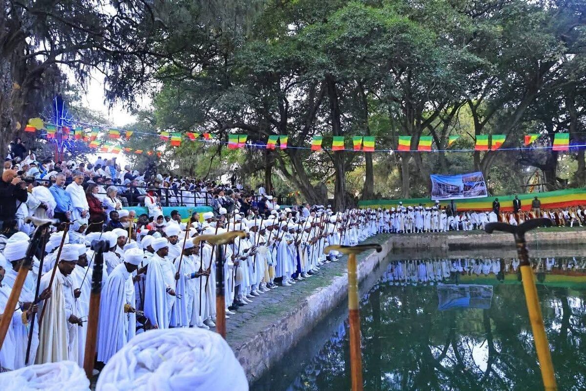 Priests in white robes lined up beside the baptismal pool at Timkat