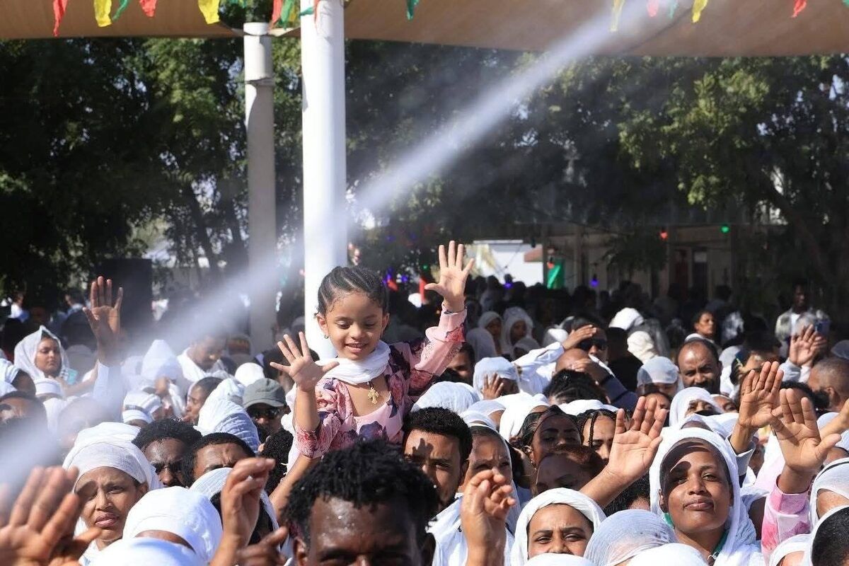 Joyful crowd with a child celebrating Timkat water blessing