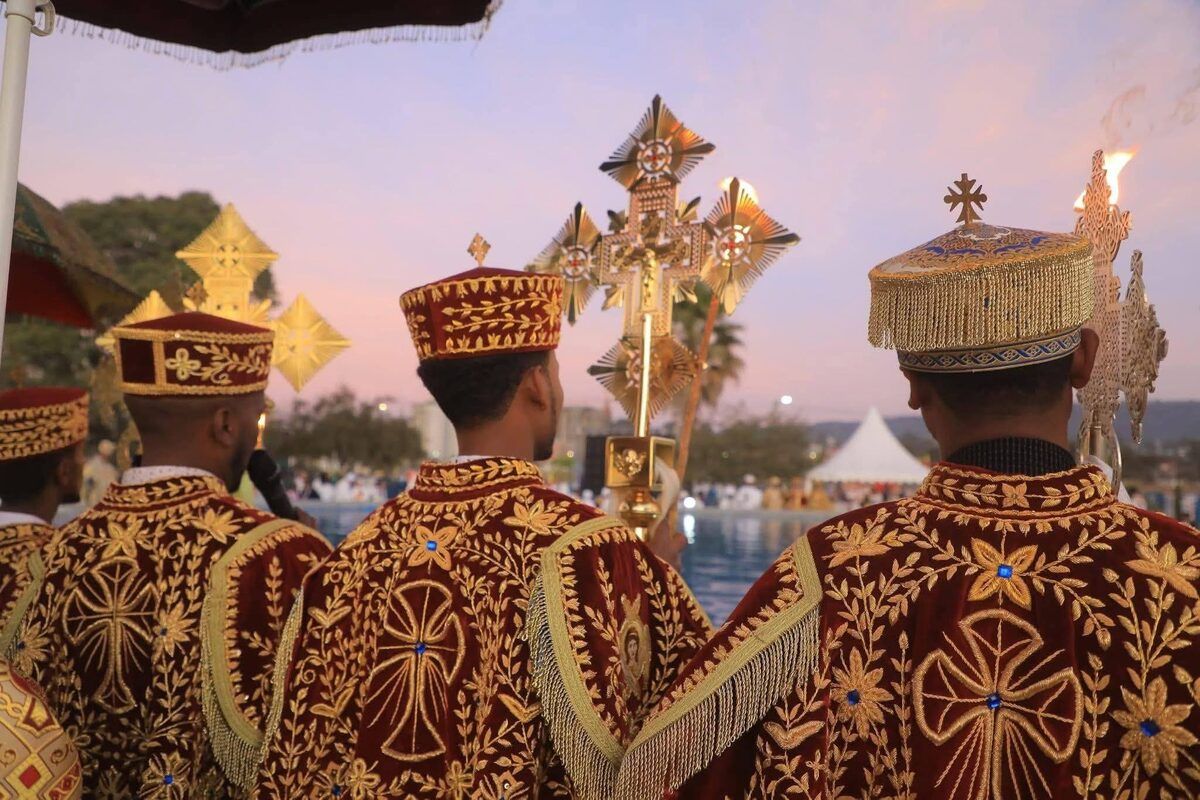 Timkat celebration with crowds in white robes and Ethiopian flags